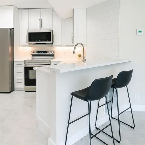 a kitchen with appliances a sink and cabinets