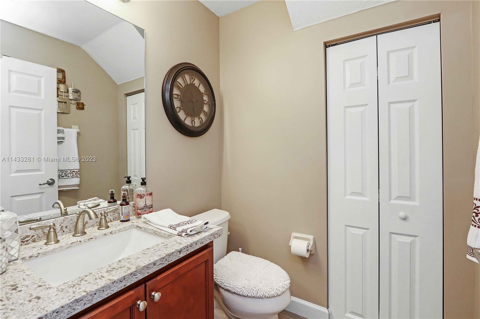 11363 Southwest 240th Street Homestead, FL 33032 - Photo 14 of 39 a bathroom with a granite countertop toilet a sink and a mirror