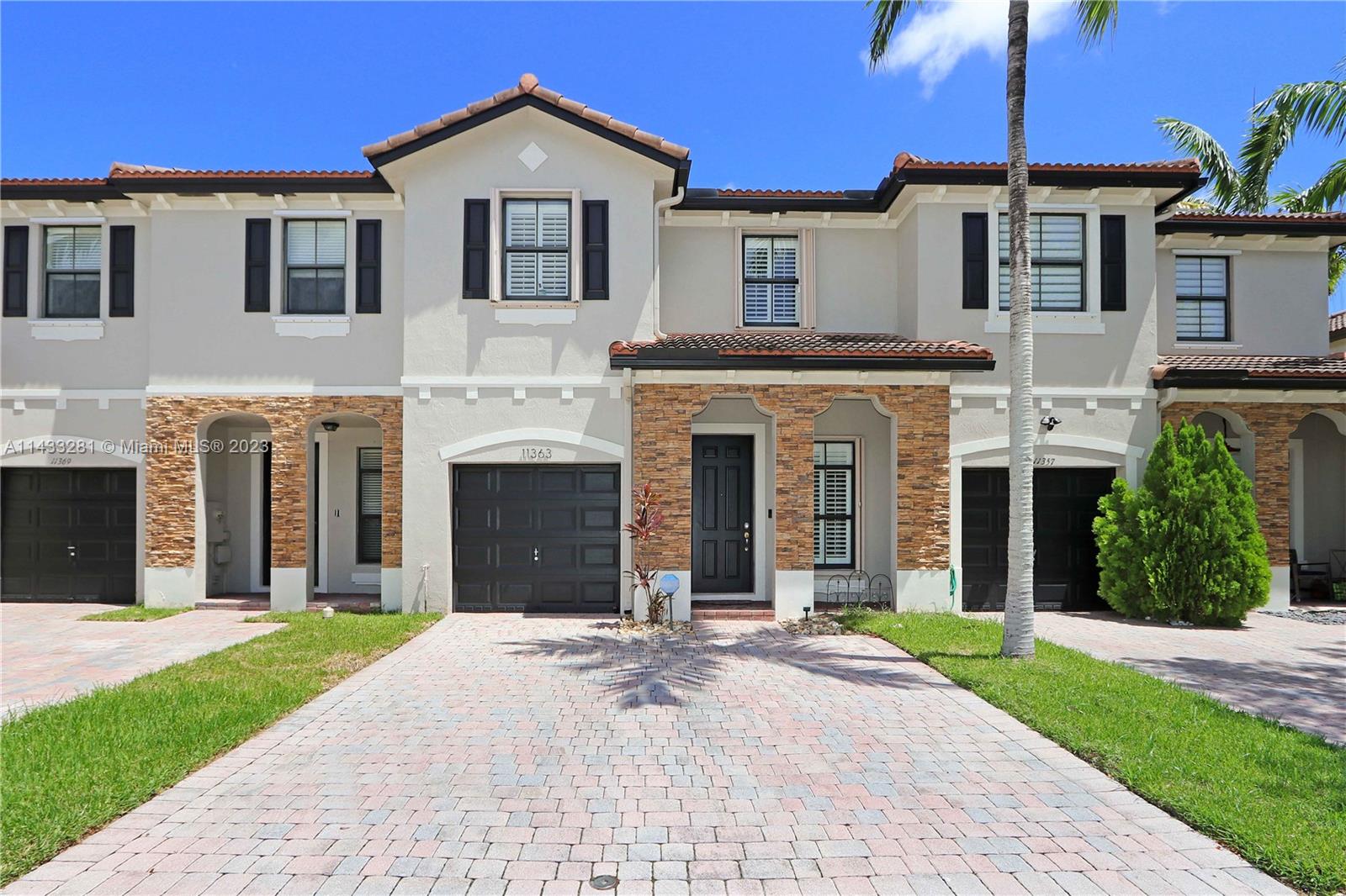 11363 Southwest 240th Street Homestead, FL 33032 - Photo 3 of 39 a front view of a house with a yard and garage