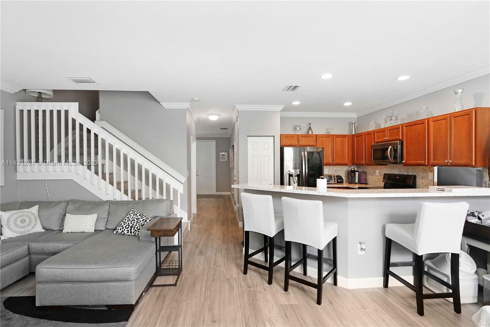11363 Southwest 240th Street Homestead, FL 33032 - Photo 10 of 39 a kitchen with stainless steel appliances kitchen island granite countertop a dining table chairs and a refrigerator