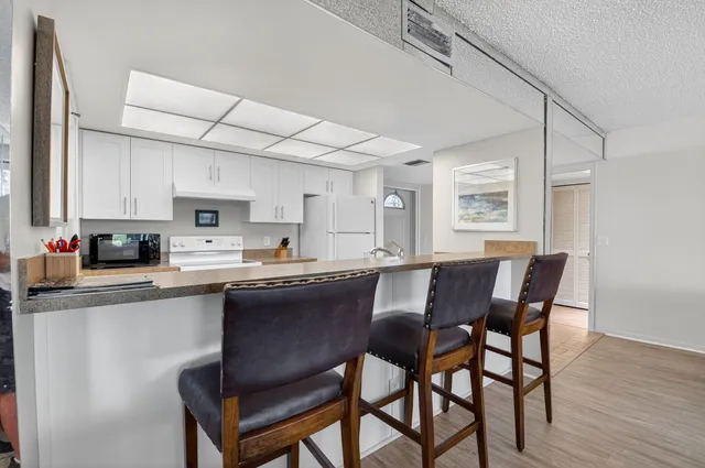a kitchen with granite countertop a sink stainless steel appliances and white cabinets