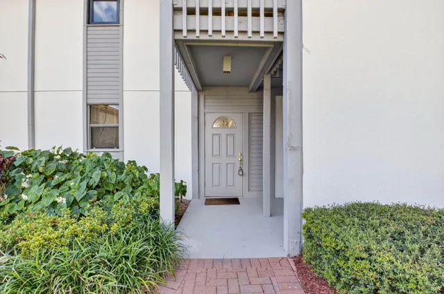 a view of a door of the house with a garden