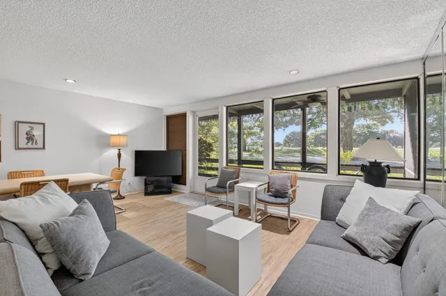 a living room with furniture large window and a flat screen tv