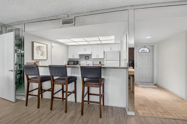 a kitchen with granite countertop a sink stove and refrigerator