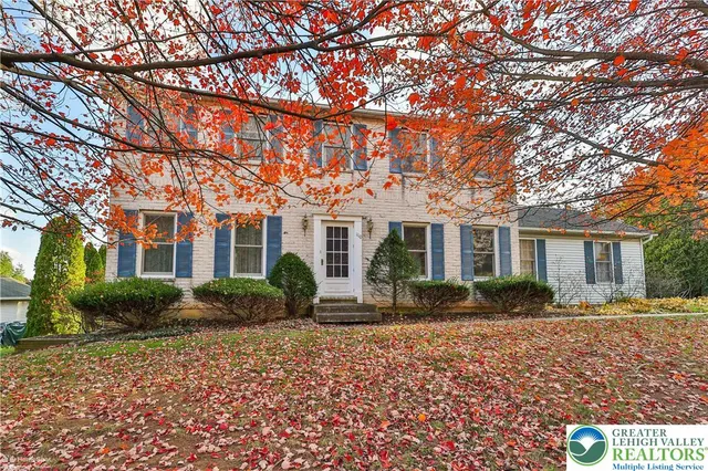 a front view of a house with yard and green space