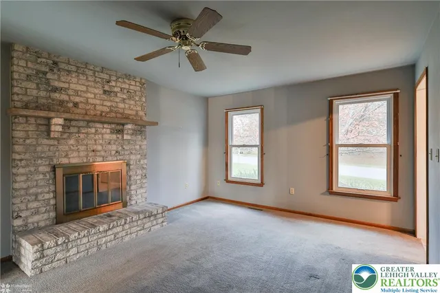 a view of an empty room with a fireplace and a window