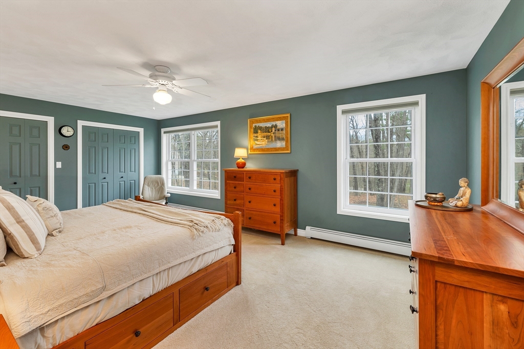 9 Juniper Ridge Road Exeter, NH 03833 - Photo 27 of 41 a bedroom with a bed and dresser with mirror