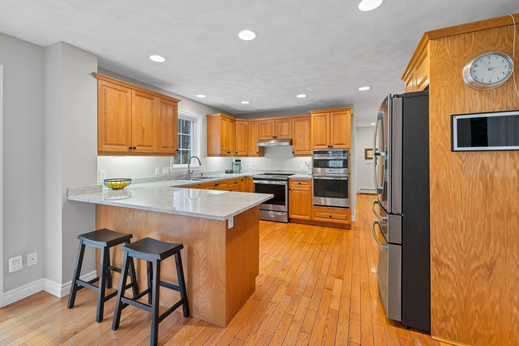9 Juniper Ridge Road Exeter, NH 03833 - Photo 10 of 41 a kitchen with stainless steel appliances granite countertop wooden cabinets a stove top oven a sink and dishwasher