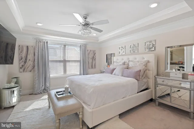 a bedroom with a large bed and a chandelier