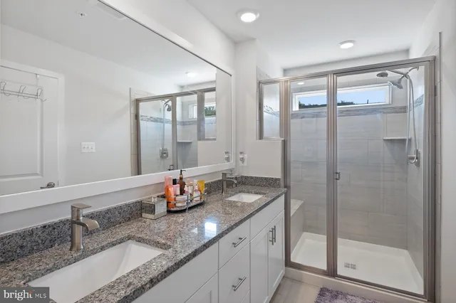 a bathroom with a granite countertop sink mirror and double