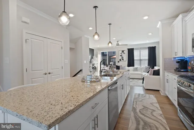 a large kitchen with kitchen island a large counter space a sink appliances and living room view