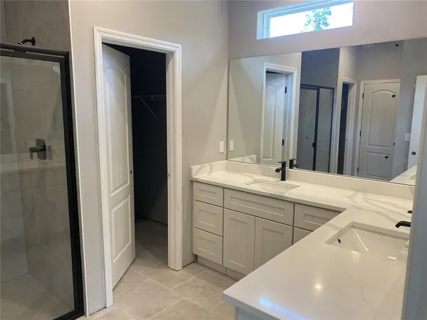 a spacious bathroom with a double vanity sink a and mirror