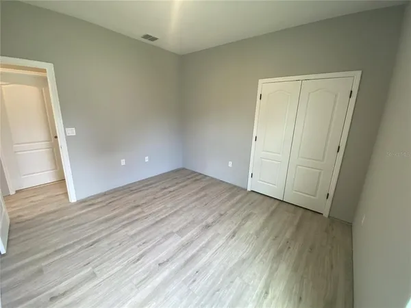 an empty room with wooden floor and entrance