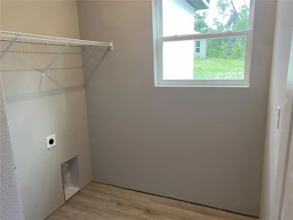 a view of a small space with wooden floor and a window