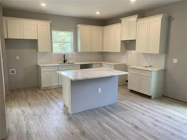 a kitchen with a sink a stove and cabinets