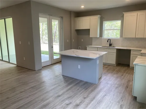 a kitchen with a sink window and cabinets