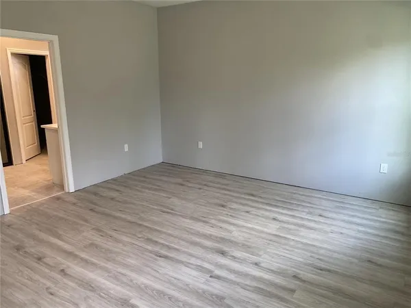 a view of empty room with wooden floor