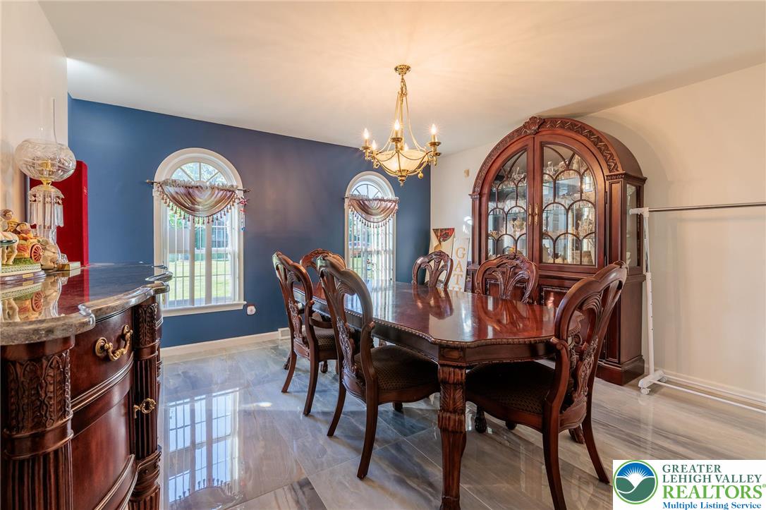 2170 Clearview Road Coplay, PA 18037 - Photo 17 of 75 Elegant dining space features arched windows and a classic chandelier, ideal for memorable gatherings.