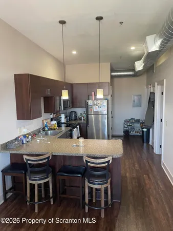 a kitchen with a dining table chairs refrigerator and microwave