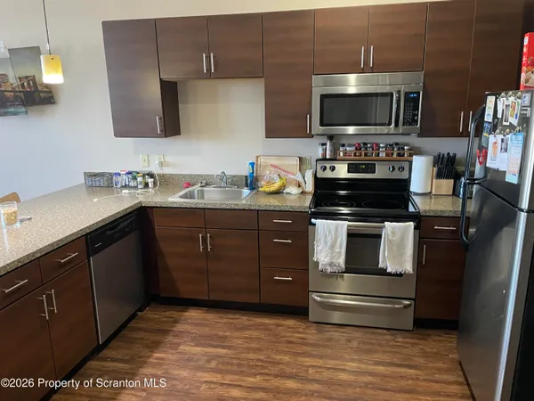 a kitchen with a sink and steel appliances