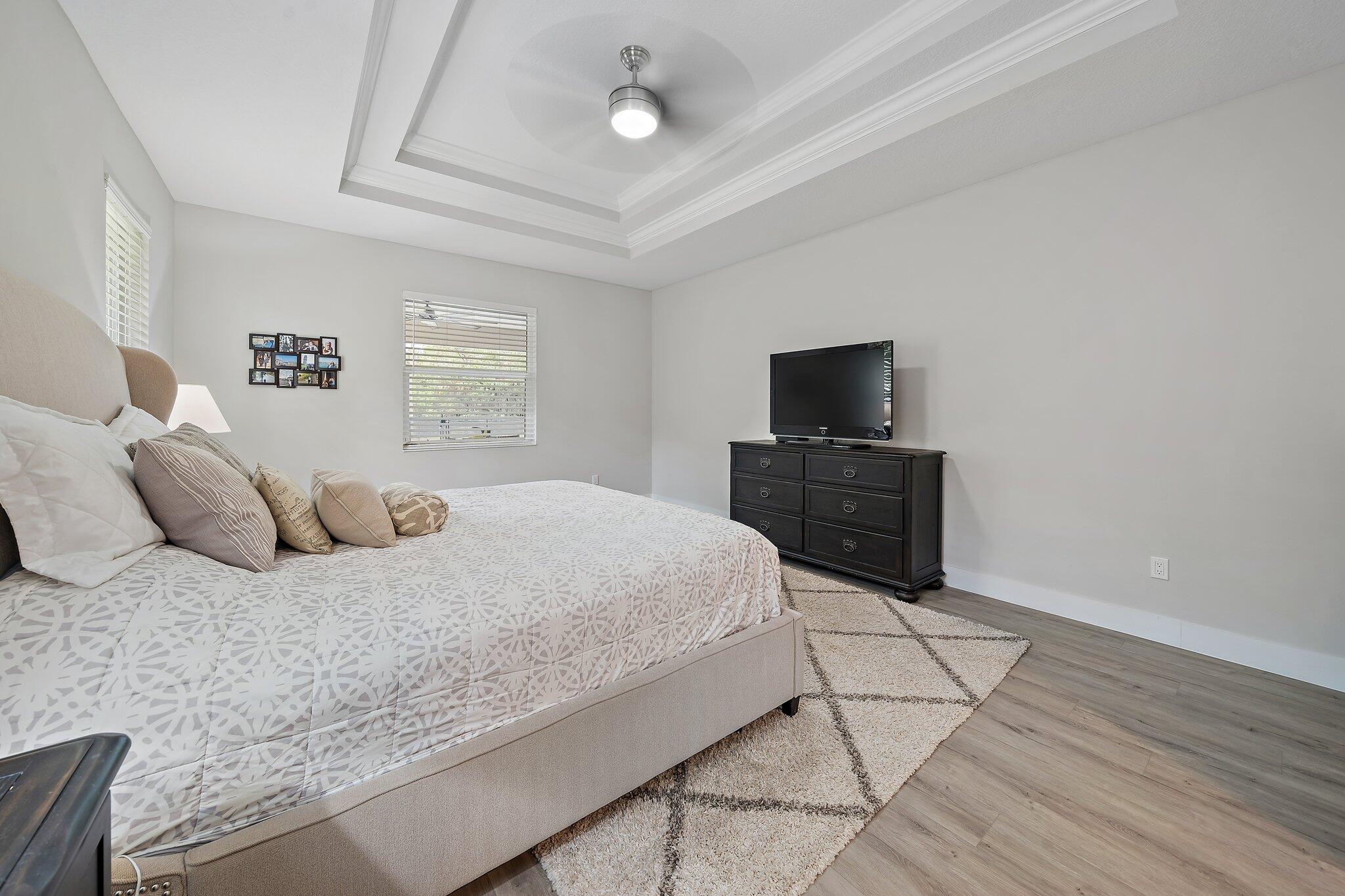 12216 175th Road North Jupiter, FL 33478 - Photo 25 of 57 a bedroom with a bed and a flat tv screen on dresser