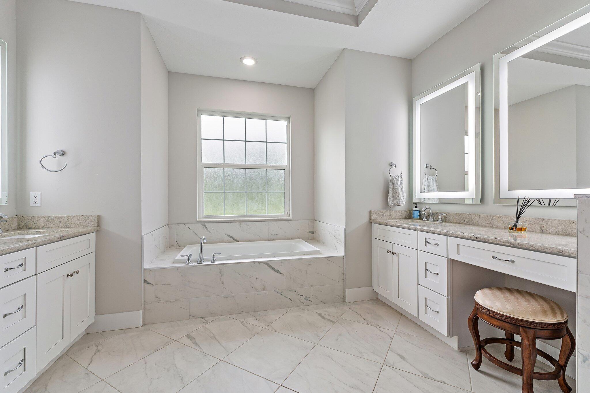 12216 175th Road North Jupiter, FL 33478 - Photo 27 of 57 a spacious bathroom with a granite countertop tub sink and mirror