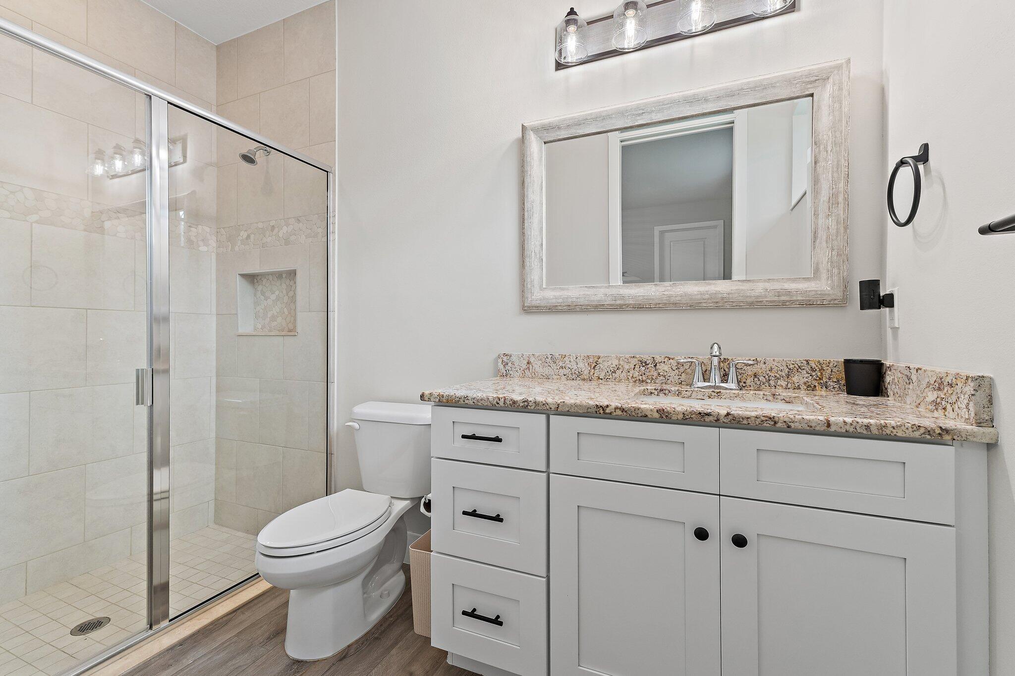 12216 175th Road North Jupiter, FL 33478 - Photo 38 of 57 a bathroom with a granite countertop sink a toilet and a shower