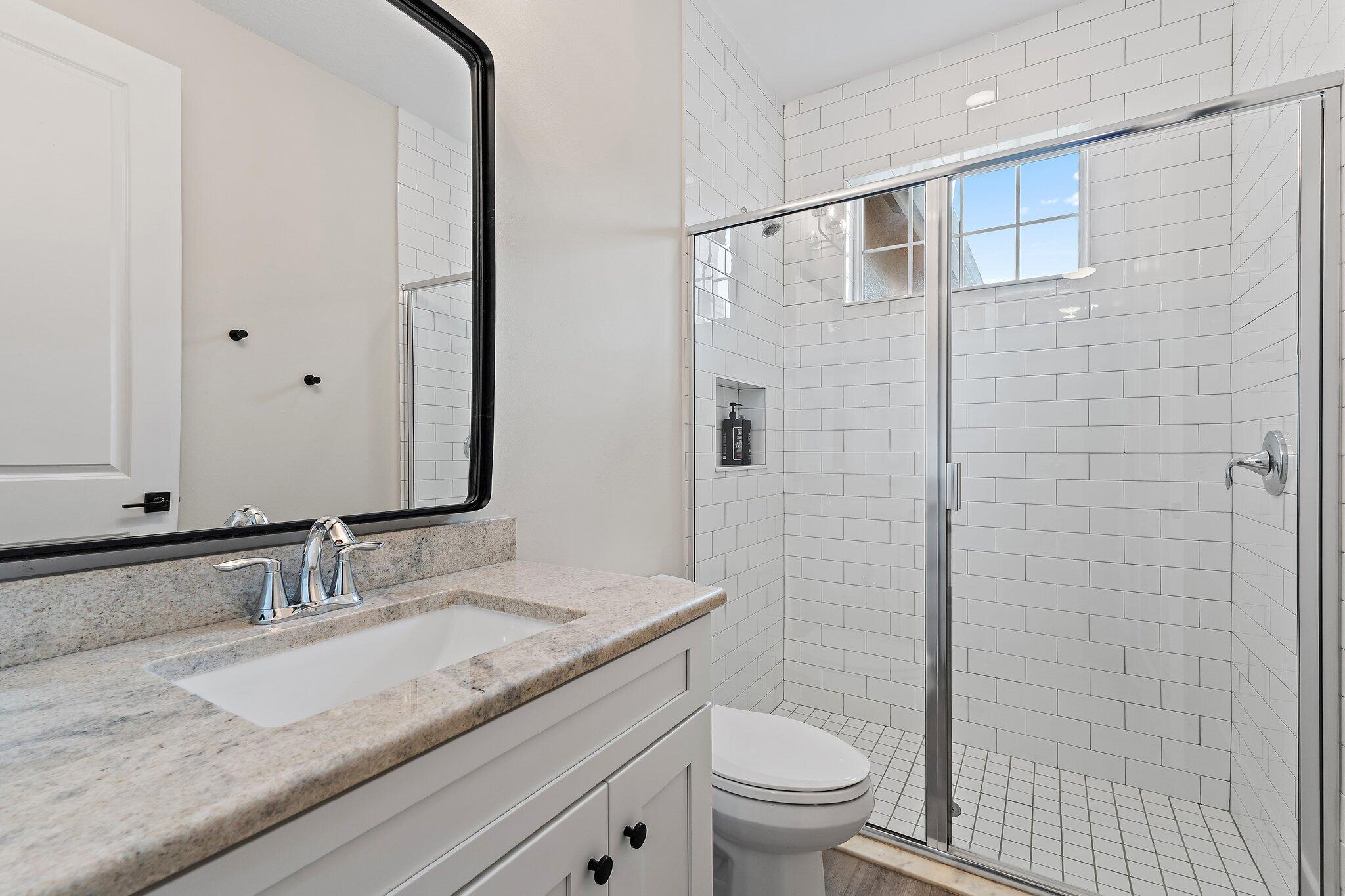 12216 175th Road North Jupiter, FL 33478 - Photo 41 of 57 a bathroom with a granite countertop sink a toilet and shower