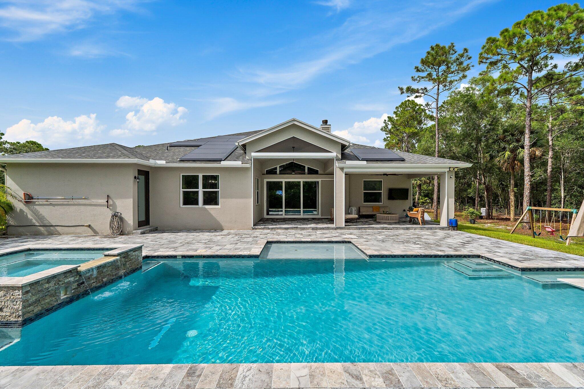 12216 175th Road North Jupiter, FL 33478 - Photo 50 of 57 a front view of a house with swimming pool having outdoor seating