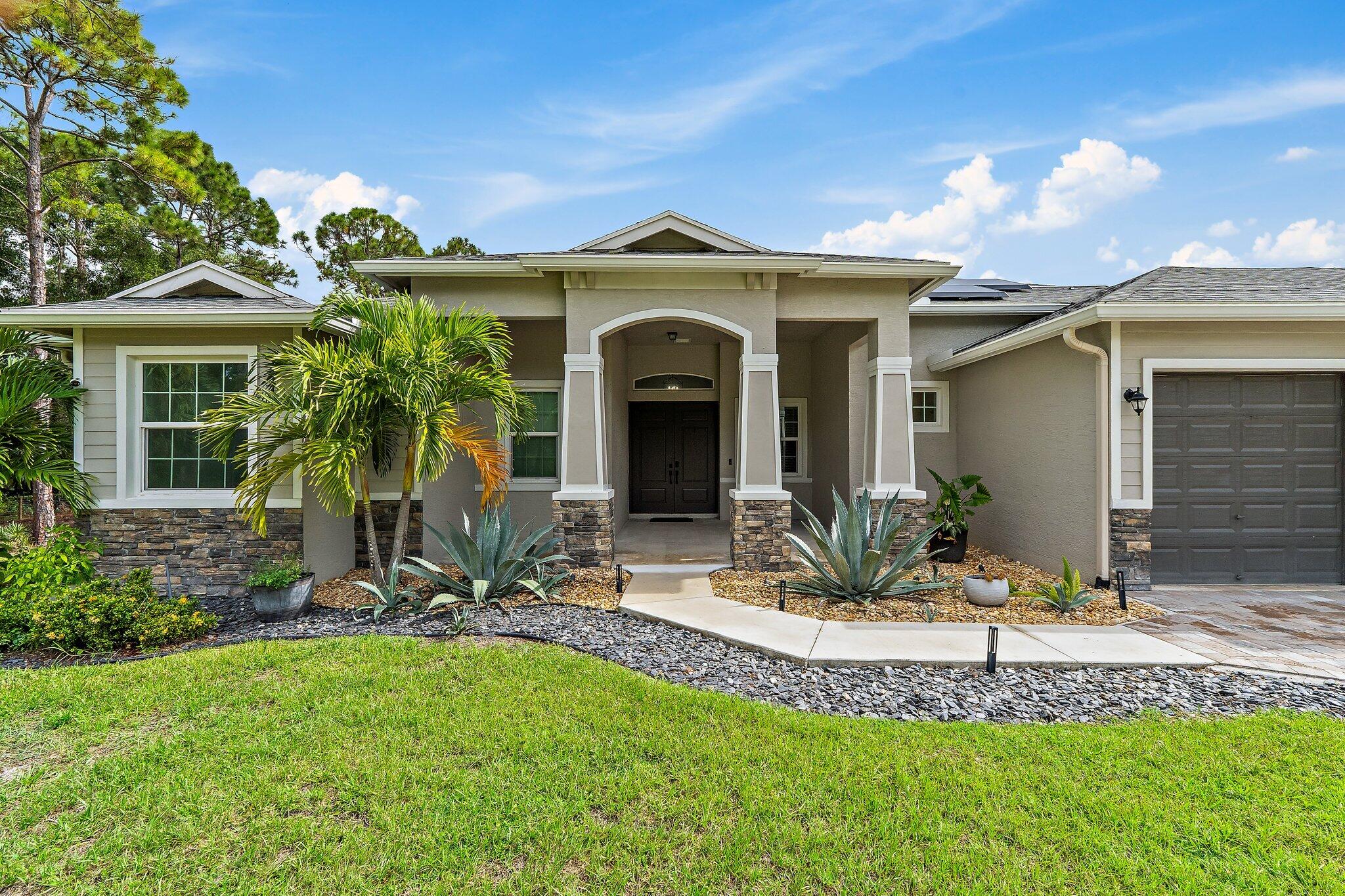 12216 175th Road North Jupiter, FL 33478 - Photo 7 of 57 a view of a house with a yard and plants