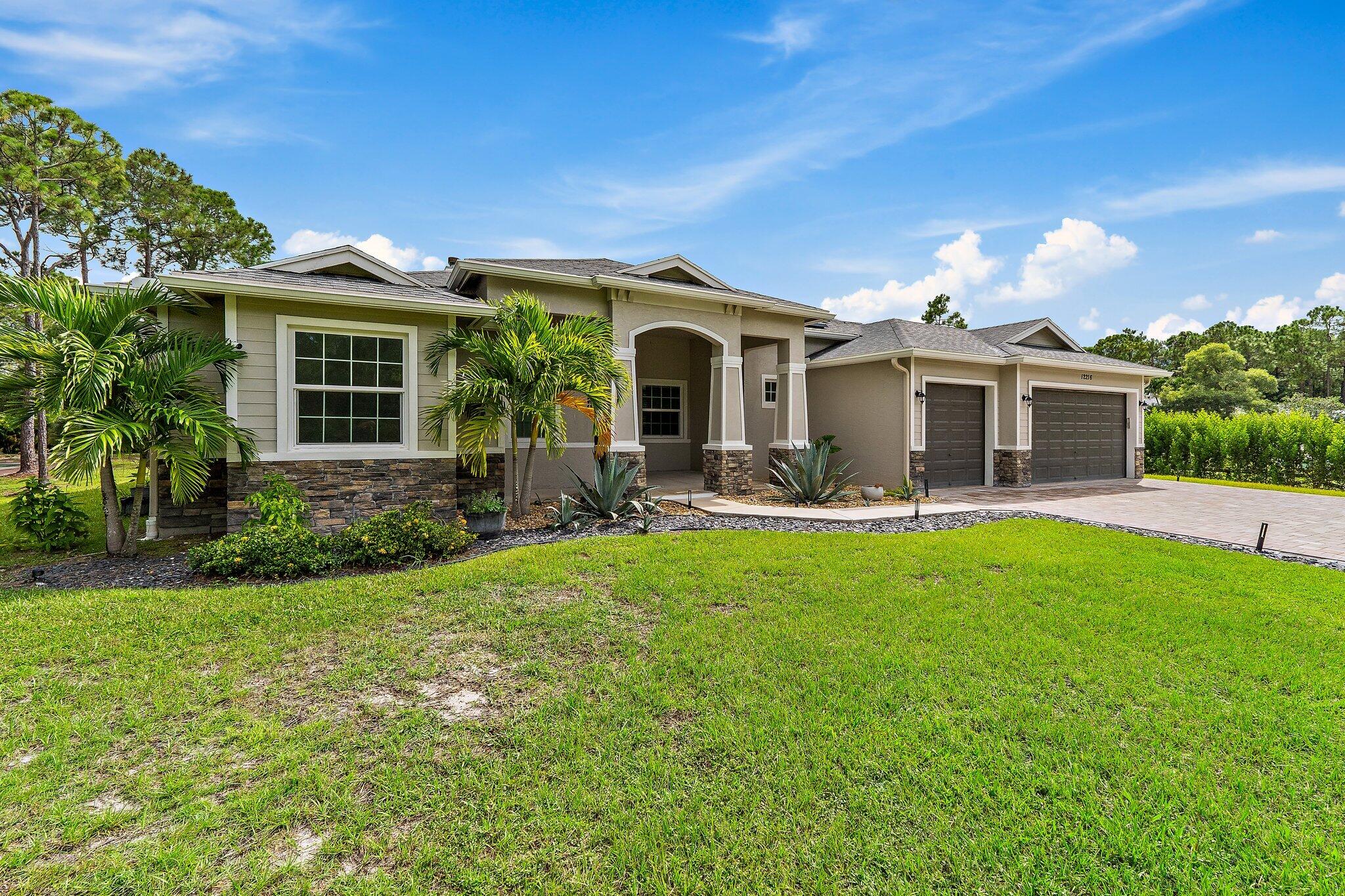 12216 175th Road North Jupiter, FL 33478 - Photo 8 of 57 a front view of house with yard and green space