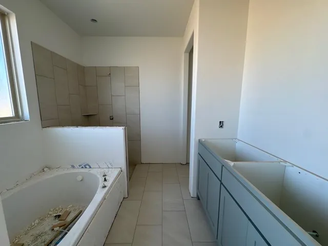 a bathroom with a tub a sink and a bathtub