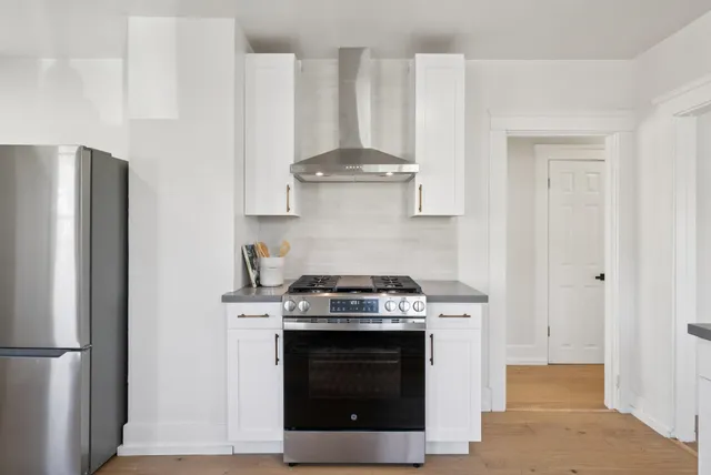 a stove top oven sitting inside of a kitchen