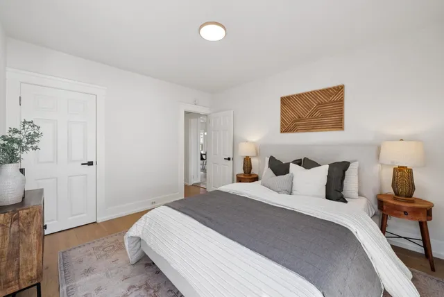 a bedroom with a bed and wooden floor