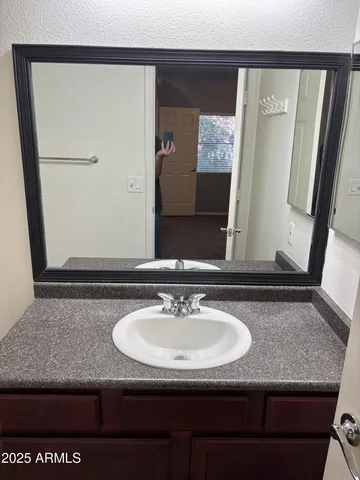 a bathroom with a granite countertop sink and a mirror