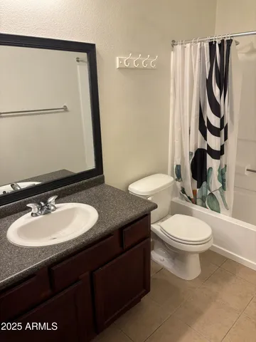 a bathroom with a granite countertop toilet sink and mirror
