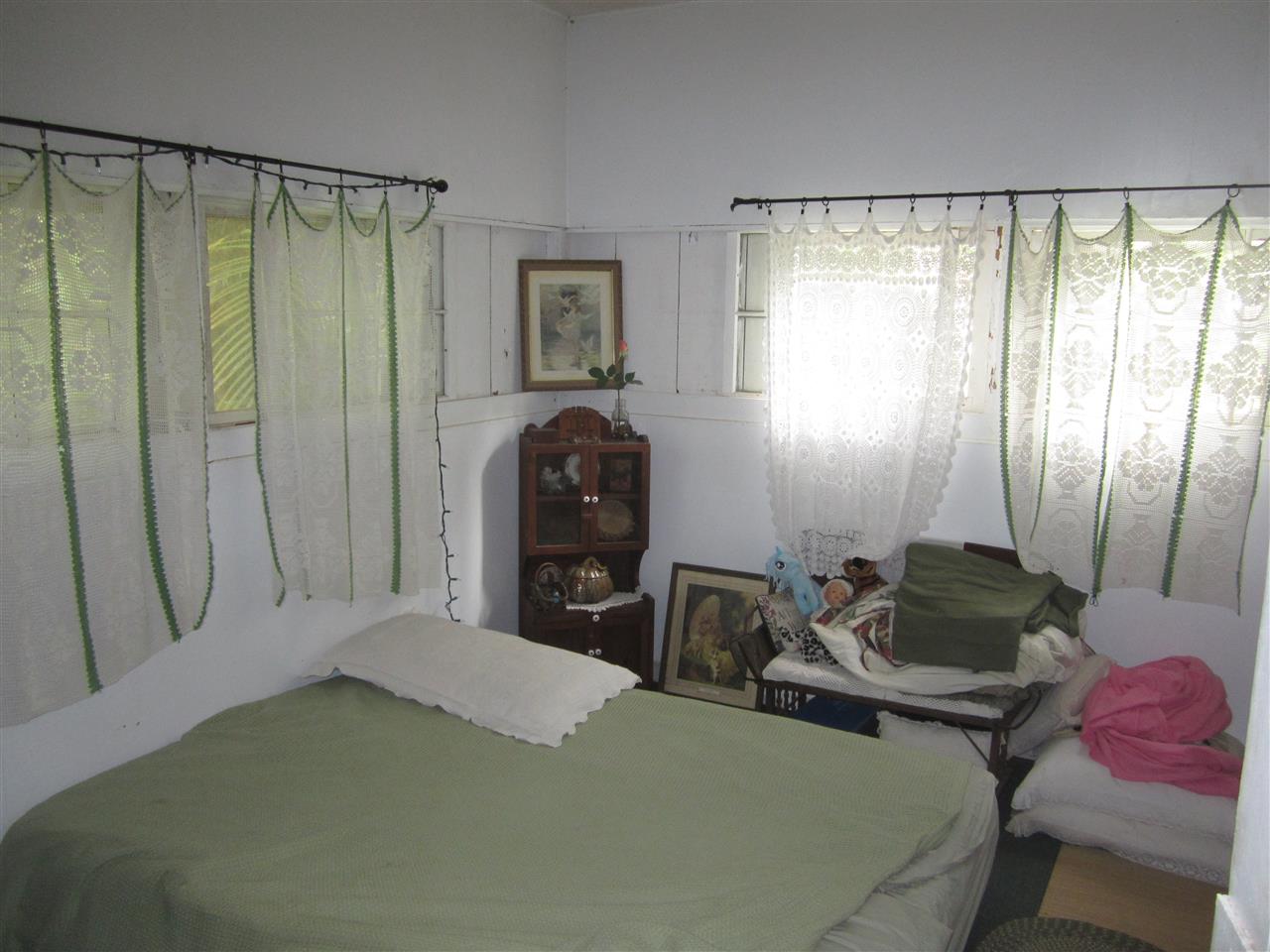 1085 West Kuiaha Road Haiku, HI 96708 - Photo 11 of 23 a bedroom with a bed and a chair