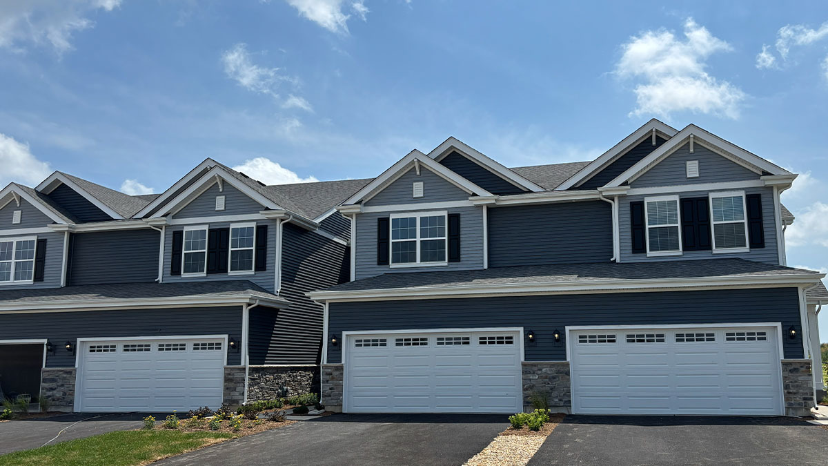 a front view of a house with a garage and a yard