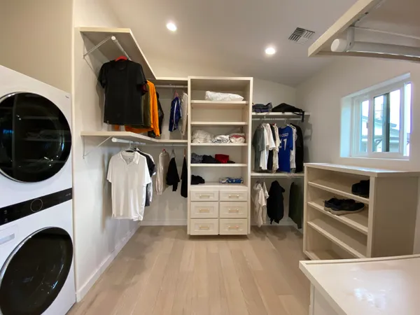 a view of walk in closet with clothes and shoes