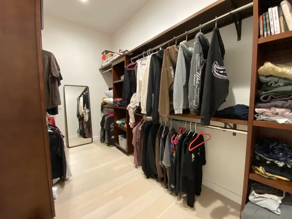 a view of walk in closet with clothes and shoes