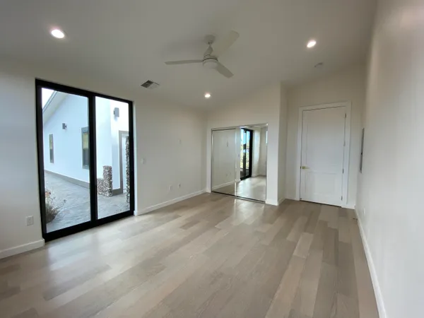 an empty room with wooden floor and mirror