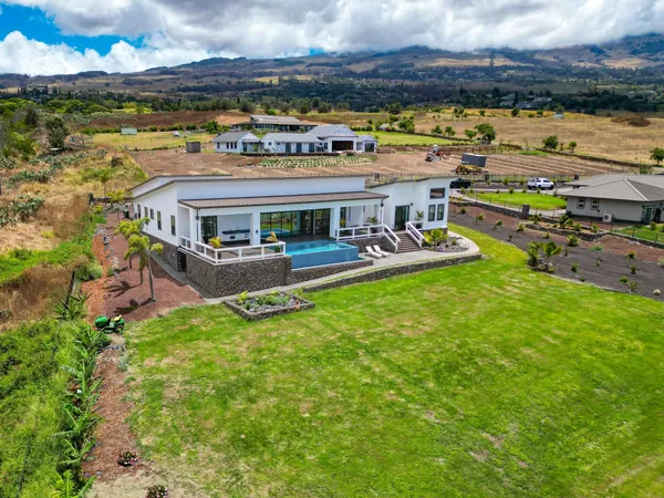 an aerial view of a house with a garden and lake view