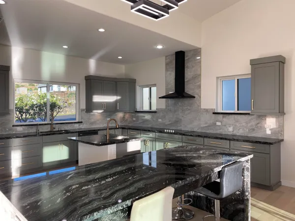 a kitchen with stainless steel appliances granite countertop a stove a sink and a microwave