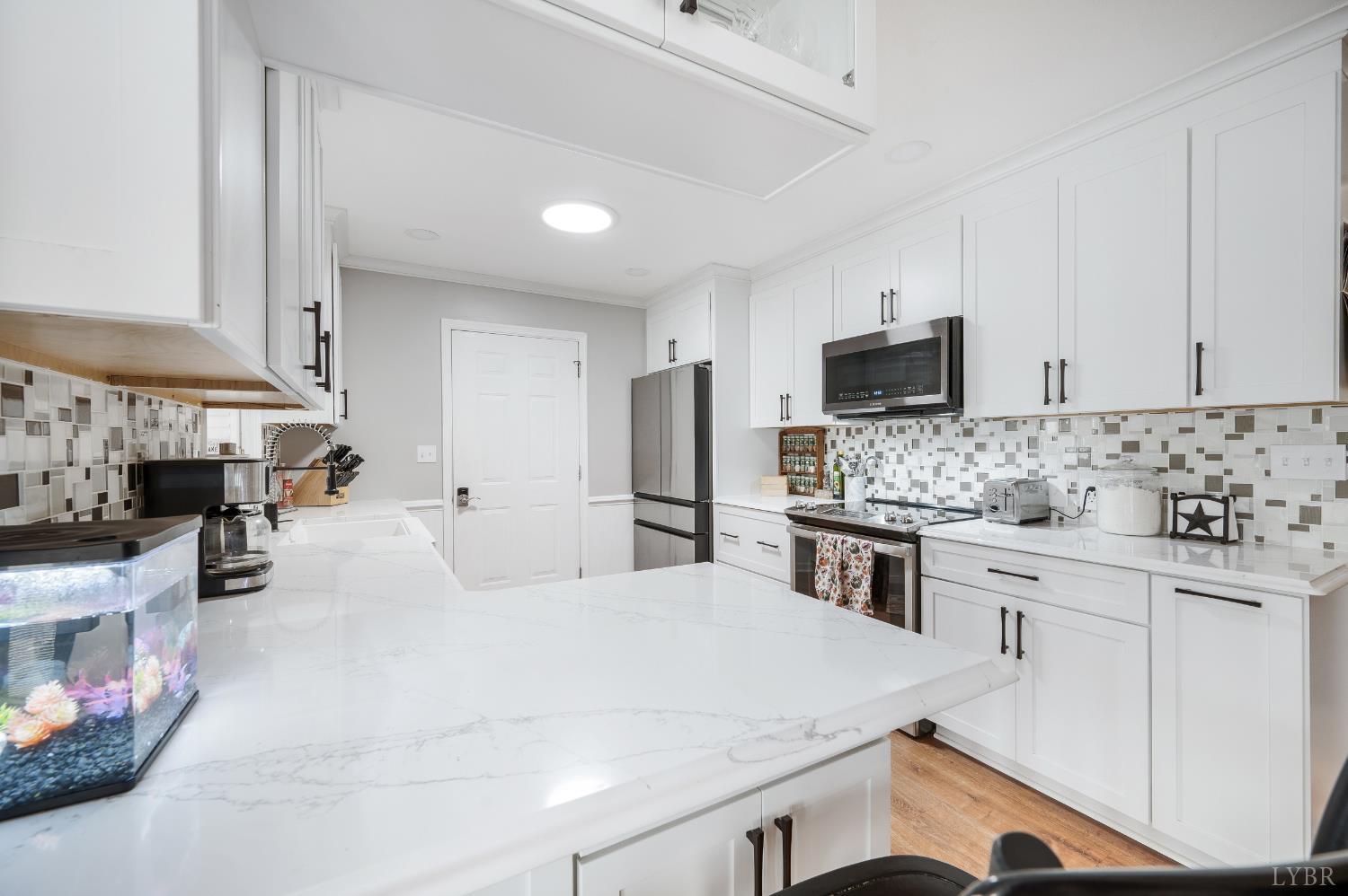 192 Liberty Chapel Road Appomattox, VA 24522 - Photo 13 of 60 a kitchen with stainless steel appliances a stove sink microwave and cabinets