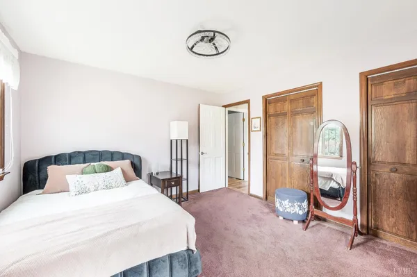 a bedroom with a large bed and a chandelier
