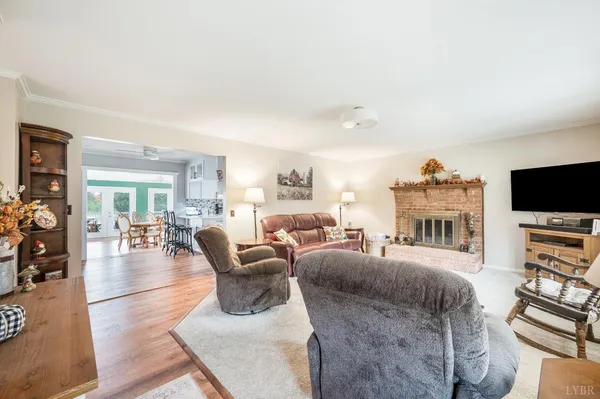 a living room with furniture a flat screen tv and a large window