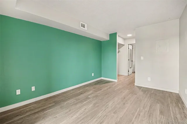a view of empty room with wooden floor