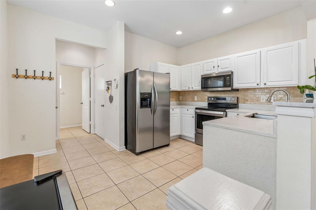 26527 Castleview Way Wesley Chapel, FL 33544 - Photo 13 of 45 a kitchen with a refrigerator a sink and a stove top oven