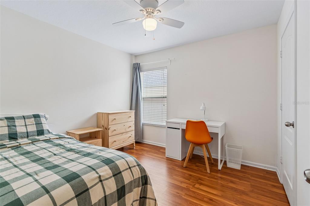 26527 Castleview Way Wesley Chapel, FL 33544 - Photo 21 of 45 a bedroom with a bed and a chair with the wooden floor