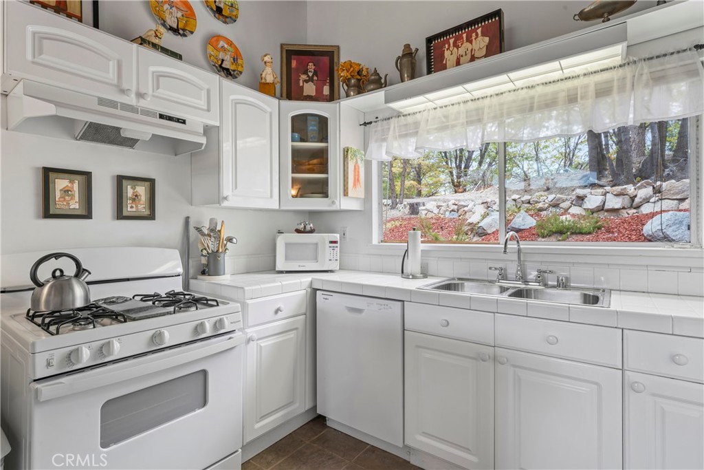705 Cypress Road Cedar Glen, CA 92321 - Photo 11 of 51 a kitchen with cabinets appliances a sink and a window